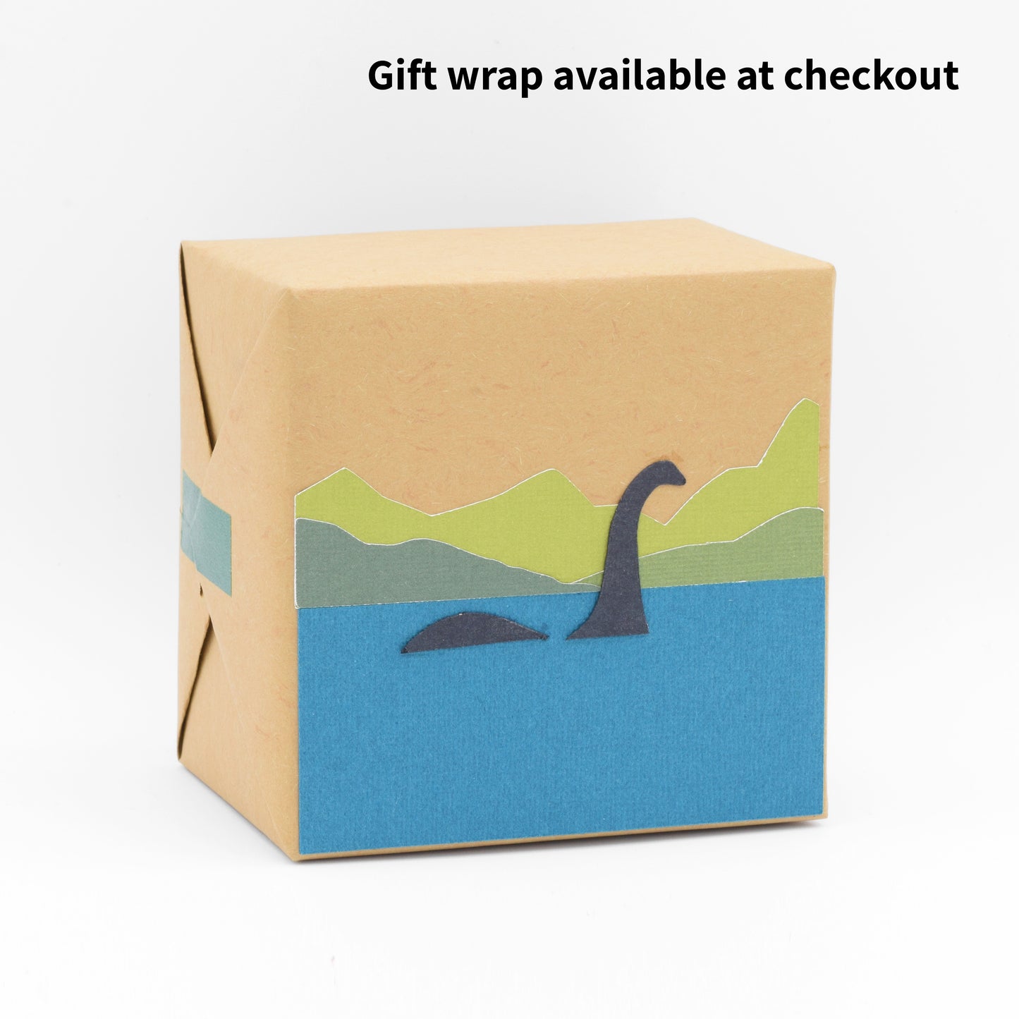 The gift wrap features a paper cutout of Nessie and scenic Loch Ness.