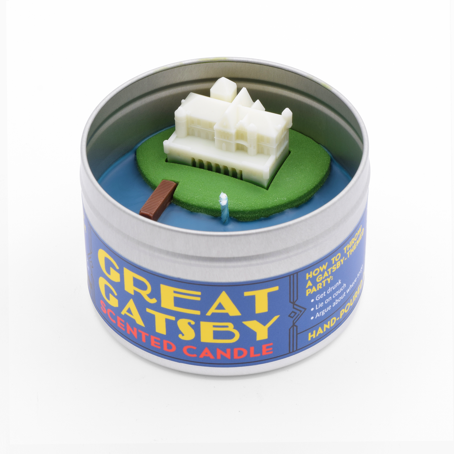 The Great Gatsby Scented Candle smells like champagne and has a miniature Gatsby mansion on its surface, complete with dock.