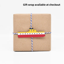 Load image into Gallery viewer, The gift wrap features a paper cutout of the warship the USS Maine. 