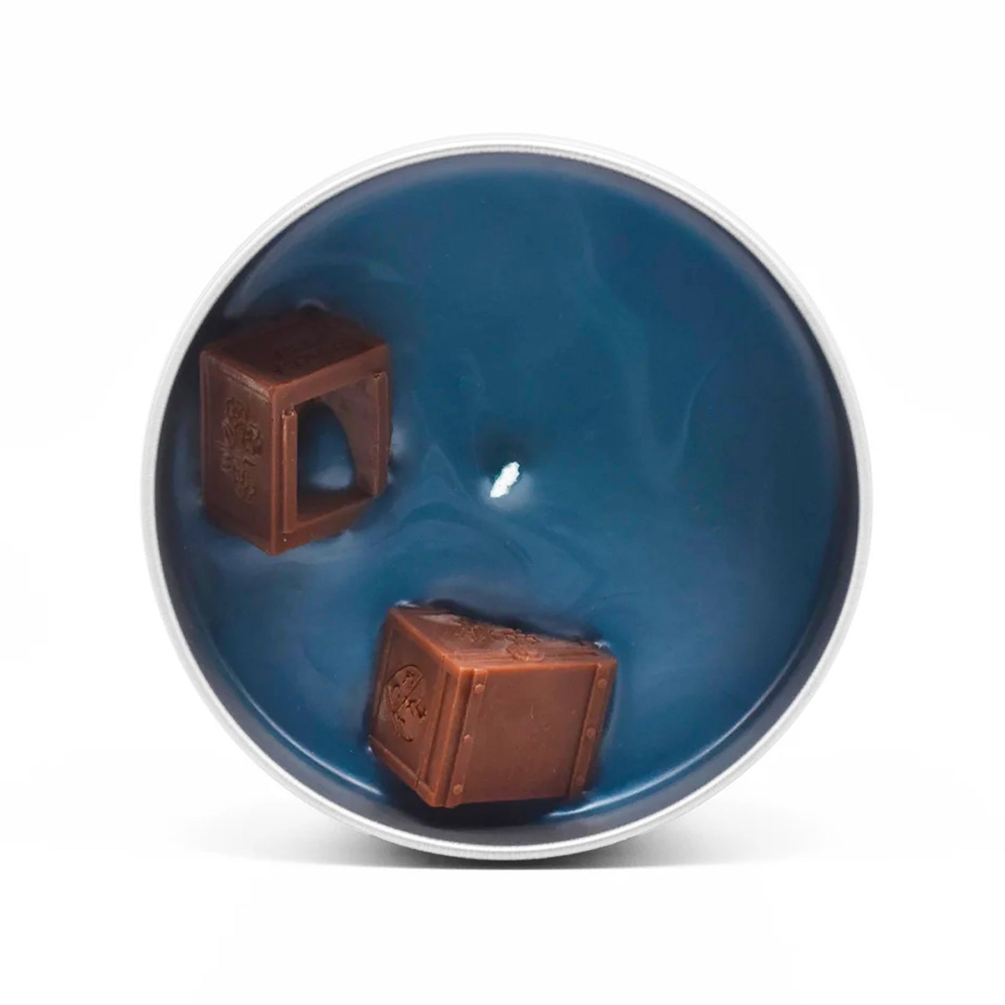 The surface of the candle features two wax tea chests modeled after the actual tea chests that were thrown overboard during the Boston Tea Party. 