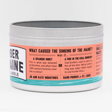 Load image into Gallery viewer, The candle label explores some of the possible causes of the sinking of the USS Maine. 